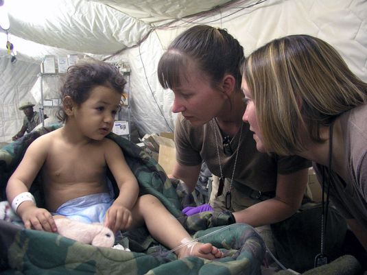 Doctors Practice P S Remesh 03 Helping young patient in healing. in Iraq. U.S. Navy Chief Journalist Al Bloom
